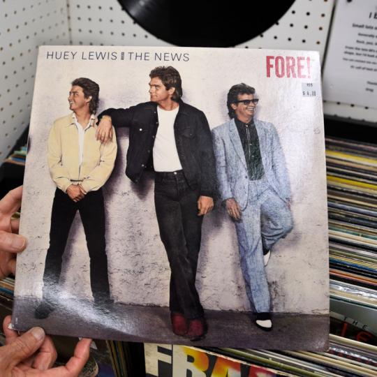 NEWPORT, OREGON - JUNE 16, 2019: A customer in an antiques and collectibles shop in Newport, Oregon, holds a used Huey Lewis and the News record album for sale titled 'Fore!' which was released in 1986. (Photo by Robert Alexander/Getty Images)